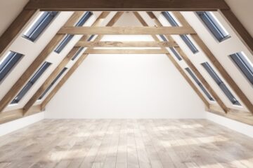 a nice-looking empty attic space with a gable roof, plenty of windows, a wooden floor, and white walls