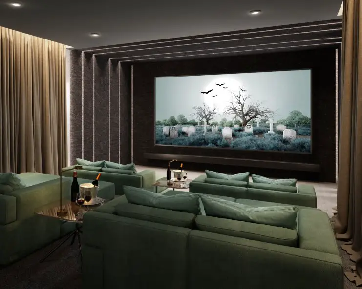 A dark home theater with a large screen, four two-seat couches, two small tables with drinks, and curtains on the walls.