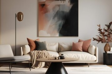 A modern living room with a cream sofa, accent chair, round coffee table, abstract wall art, and coordinating plants.